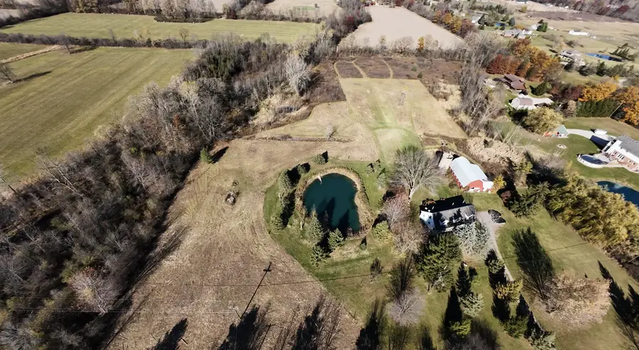 Aerial view of a rural property with a pond, cleared ground and treelines