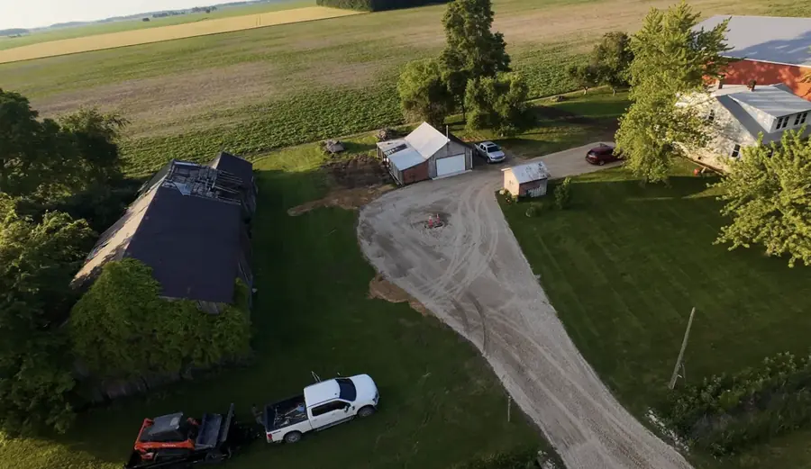 Aerial view of a gravel drive curving up to a house in the country