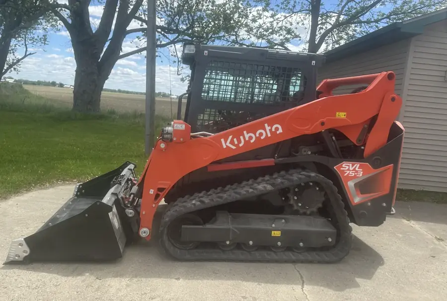 Orange Kubota compact track loader parked on a driveway
