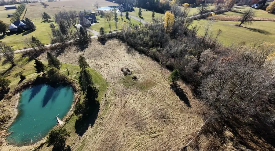 Aerial view of brush cleared from around a pond on a rural property