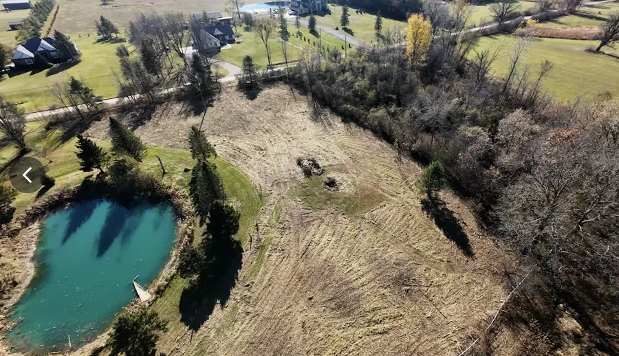 After: Several acres of overgrown ground around a pond, mulched and cleared back to open, usable field.