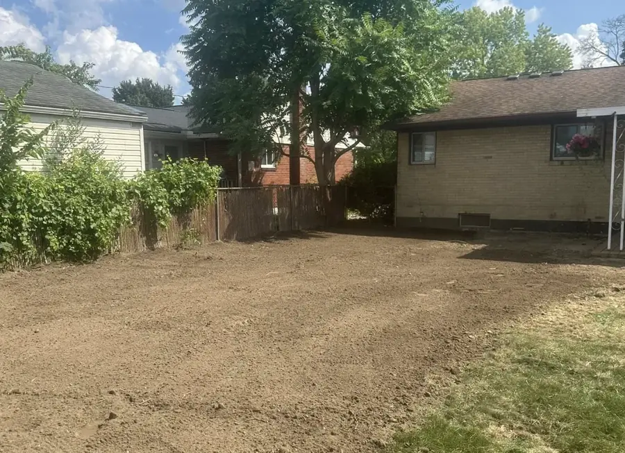 Yard between two houses cut to grade and left as bare soil